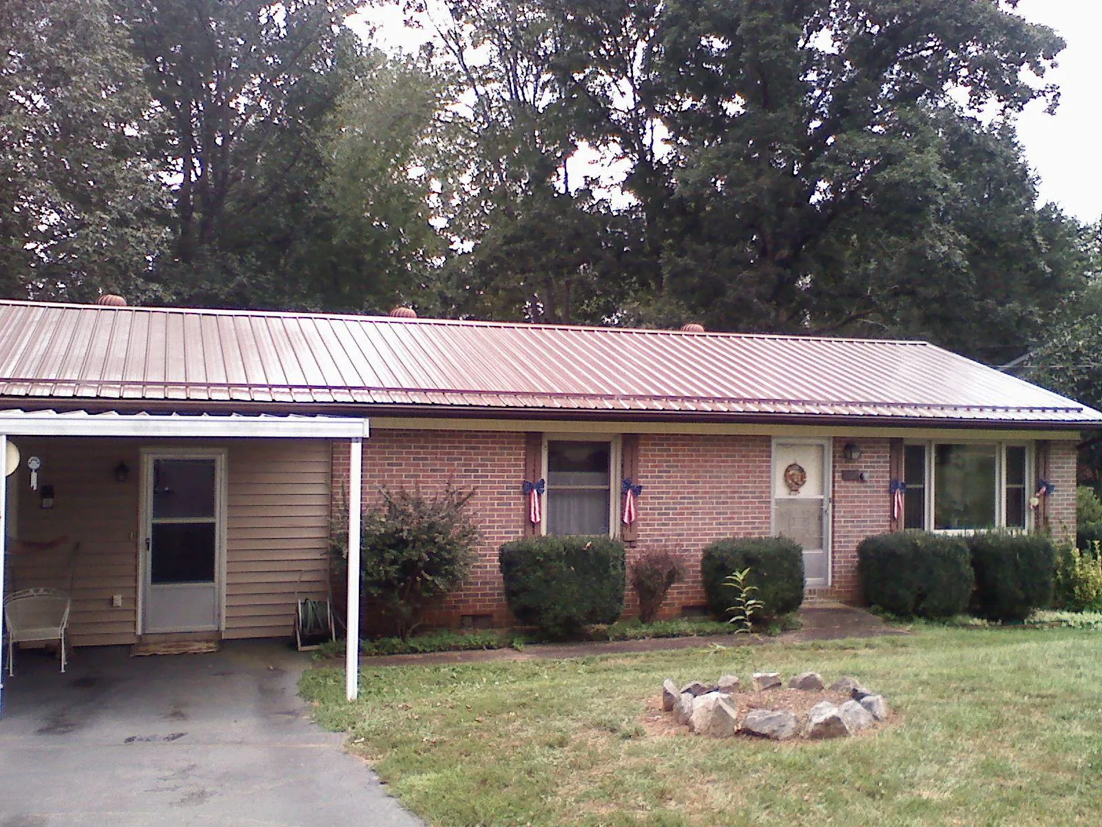 Bronze metal roof and carport on a brick ranch home — Roof Repair work by our crew in Ponderay